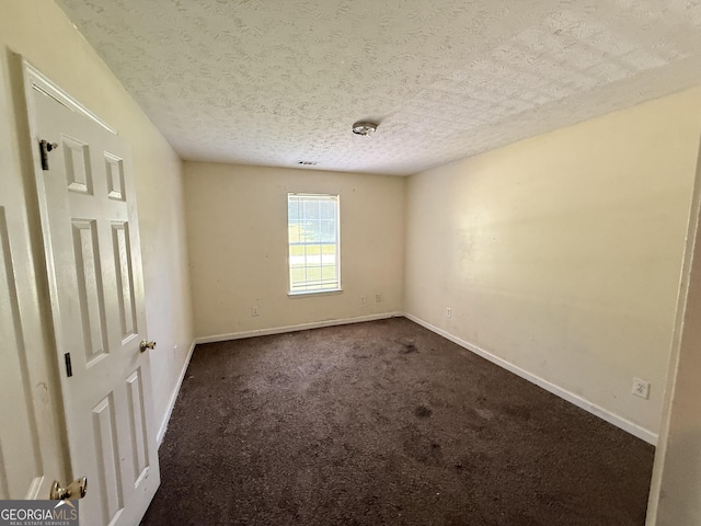 270 Mountain Way, Covington, GA 30016 - spare room featuring baseboards, dark carpet, and a textured ceiling