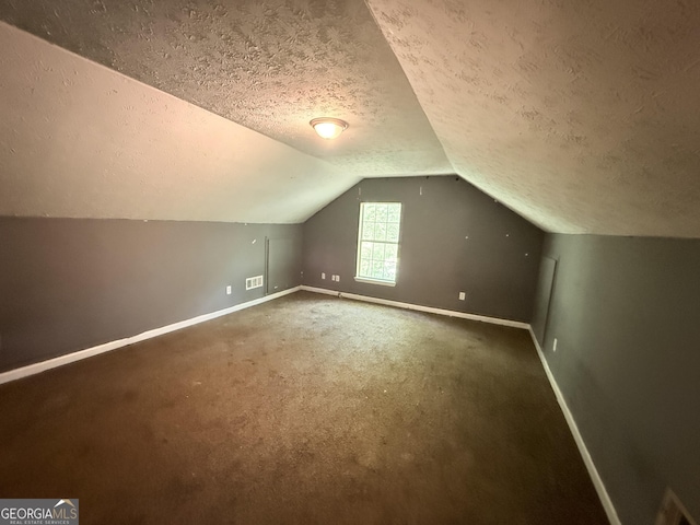 270 Mountain Way, Covington, GA 30016 - bonus room with baseboards, a textured ceiling, lofted ceiling, and carpet flooring