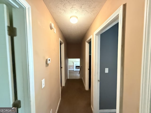 270 Mountain Way, Covington, GA 30016 - corridor with a textured ceiling, dark carpet, and baseboards