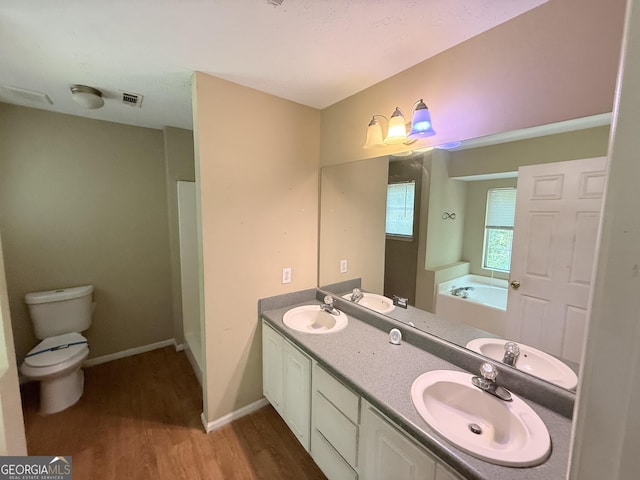 270 Mountain Way, Covington, GA 30016 - full bathroom featuring wood finished floors, toilet, a garden tub, double vanity, and baseboards