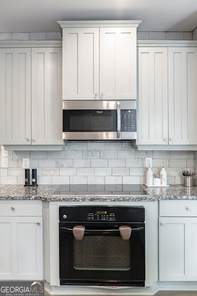 4046 Creekview Ridge Dr, Buford, GA 30518 - kitchen with black appliances, tasteful backsplash, light stone countertops, and white cabinetry