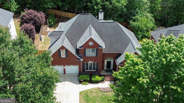 4046 Creekview Ridge Dr, Buford, GA 30518 - view of front of home featuring driveway, a chimney, roof with shingles, an attached garage, and brick siding