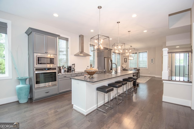 1 Newnan Views Cir, Newnan, GA 30263 - kitchen featuring appliances with stainless steel finishes, wall chimney exhaust hood, gray cabinetry, a center island with sink, and recessed lighting