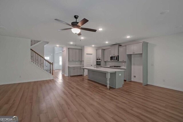 420 Tavistock Ct, Mcdonough, GA 30252 - kitchen with gray cabinets, stainless steel appliances, open floor plan, wood finished floors, and recessed lighting