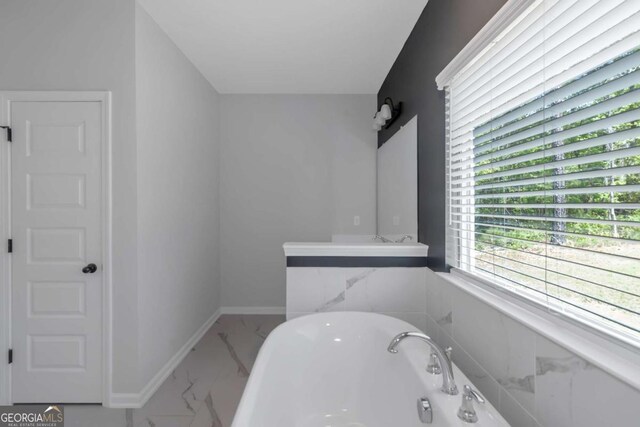 420 Tavistock Ct, Mcdonough, GA 30252 - bathroom featuring marble finish floors, a soaking tub, and baseboards