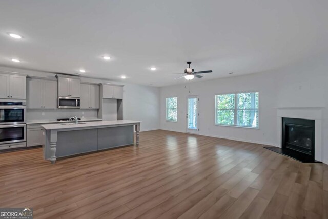 420 Tavistock Ct, Mcdonough, GA 30252 - kitchen featuring appliances with stainless steel finishes, open floor plan, light countertops, light wood-style flooring, and recessed lighting