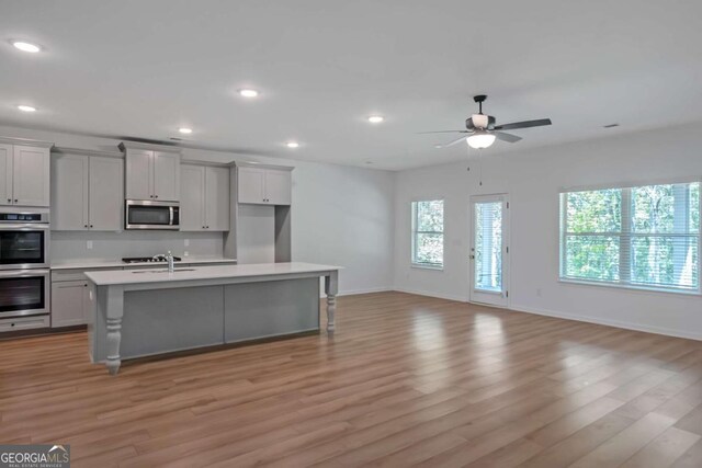 420 Tavistock Ct, Mcdonough, GA 30252 - kitchen with stainless steel appliances, gray cabinets, light countertops, light wood finished floors, and recessed lighting
