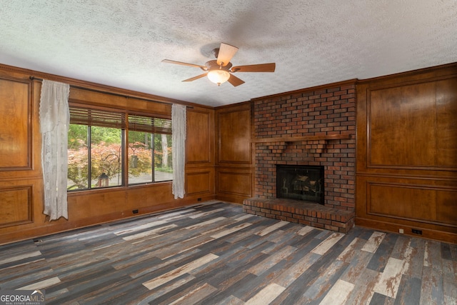 264 E Boling Rd, Jasper, GA 30143 - unfurnished living room featuring dark wood-style floors, ceiling fan, a textured ceiling, a fireplace, and wooden walls