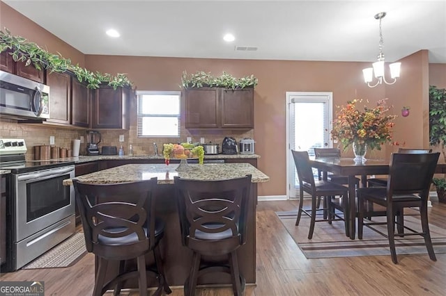 1152 Werre Way, Locust Grove, GA 30248 - kitchen featuring appliances with stainless steel finishes, a center island, backsplash, a breakfast bar area, and recessed lighting