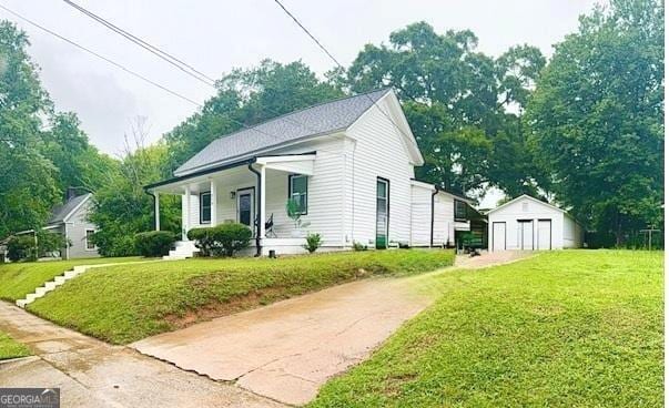 219 Broad St, Carrollton, GA 30117 - view of front facade featuring a porch, an outbuilding, a front lawn, driveway, and a garage