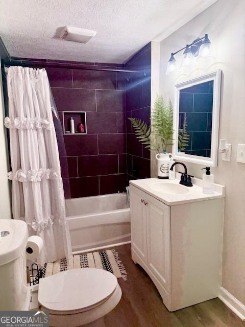 219 Broad St, Carrollton, GA 30117 - bathroom with wood finished floors, vanity, shower / bath combo with shower curtain, and a textured ceiling