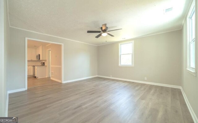 219 Broad St, Carrollton, GA 30117 - spare room with a ceiling fan, light wood finished floors, and crown molding