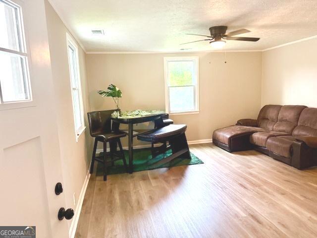 219 Broad St, Carrollton, GA 30117 - living room featuring wood finished floors, baseboards, a ceiling fan, ornamental molding, and a textured ceiling