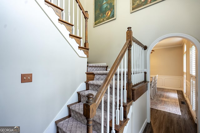 3010 White Oak Ct, Lagrange, GA 30240 - staircase featuring arched walkways, crown molding, wood finished floors, a wainscoted wall, and a decorative wall