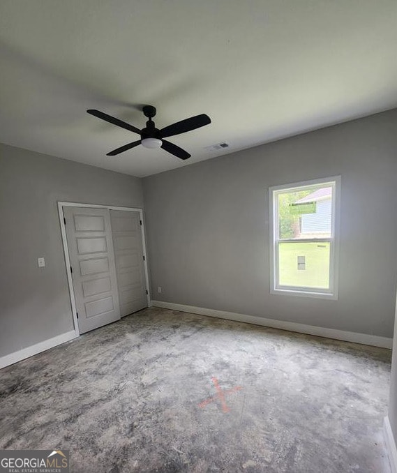 107 Silver Maple Ct, Byron, GA 31008 - unfurnished bedroom featuring unfinished concrete flooring, a closet, baseboards, and a ceiling fan