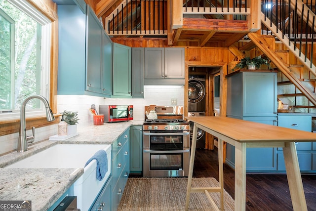 174 Little Rock Creek Ct, Cherry Log, GA 30522 - kitchen with stacked washing machine and dryer, appliances with stainless steel finishes, a sink, dark wood-style floors, and light stone counters