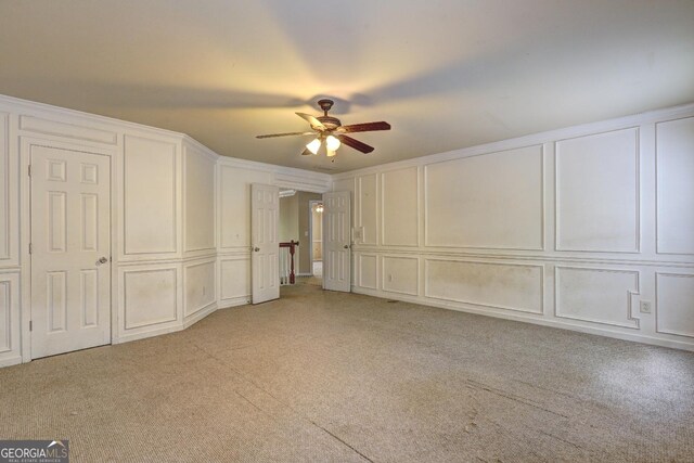 1132 Hargrove Ct, Locust Grove, GA 30248 - unfurnished bedroom featuring a decorative wall, light colored carpet, crown molding, and a ceiling fan