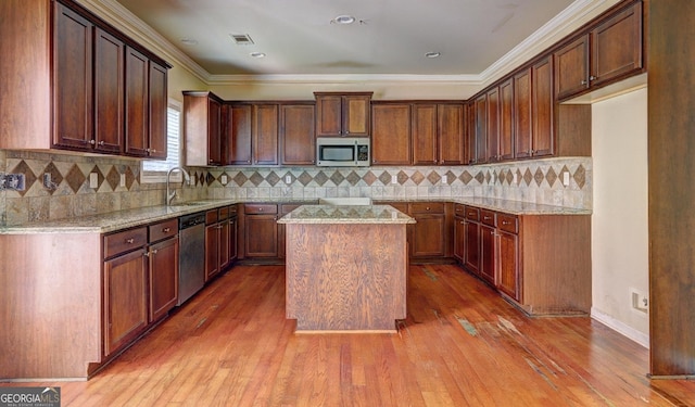 1132 Hargrove Ct, Locust Grove, GA 30248 - kitchen with appliances with stainless steel finishes, light stone counters, wood finished floors, a center island, and backsplash