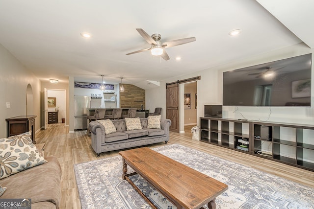 4096 Vinings Mill Trl SE, Smyrna, GA 30080 - living room with a barn door, a ceiling fan, baseboards, light wood finished floors, and arched walkways