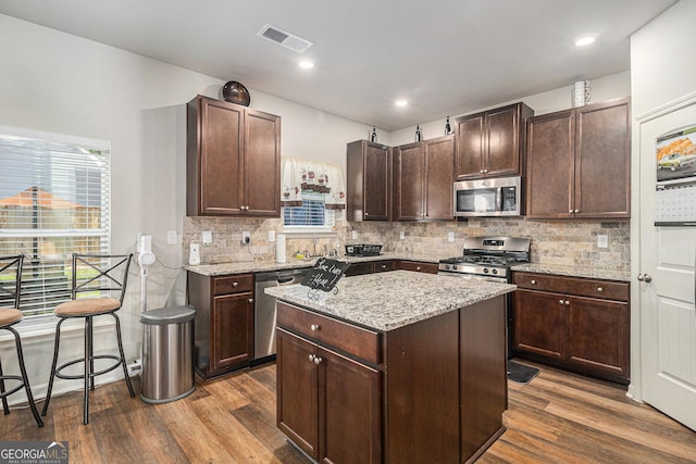 210 Kestrel Cir, Covington, GA 30014 - kitchen featuring stainless steel appliances, dark wood-type flooring, a center island, healthy amount of natural light, and recessed lighting