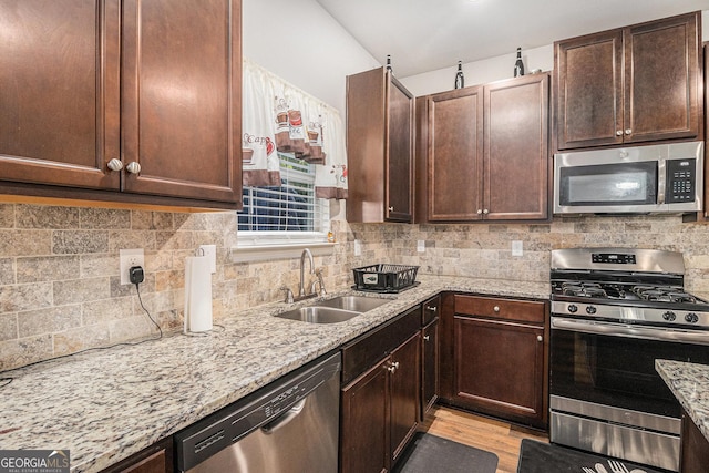 210 Kestrel Cir, Covington, GA 30014 - kitchen with stainless steel appliances, light stone countertops, light wood-type flooring, and decorative backsplash