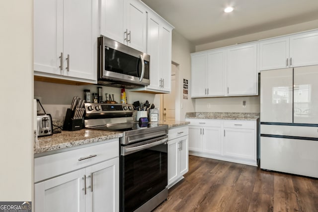 102 Olson Way, Kingsland, GA 31548 - kitchen with appliances with stainless steel finishes, white cabinetry, dark wood-style floors, and light stone countertops