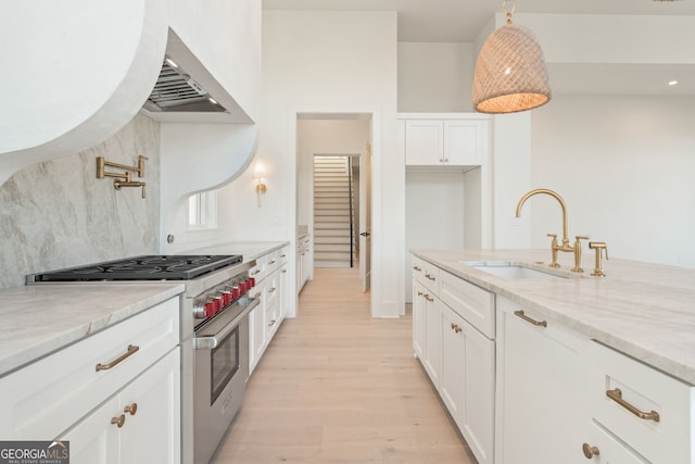 260 Guild Ln, Fayetteville, GA 30214 - kitchen with high end stainless steel range oven, extractor fan, light stone counters, light wood-style flooring, and white cabinets
