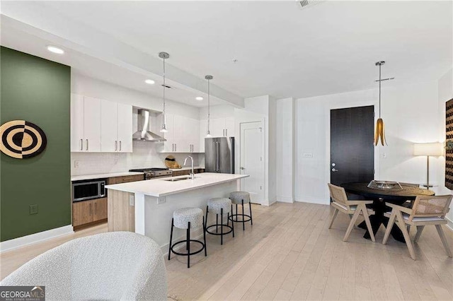 775 Juniper St NE Unit 111, Atlanta, GA 30308 - kitchen with high quality appliances, wall chimney range hood, a kitchen bar, light countertops, and recessed lighting