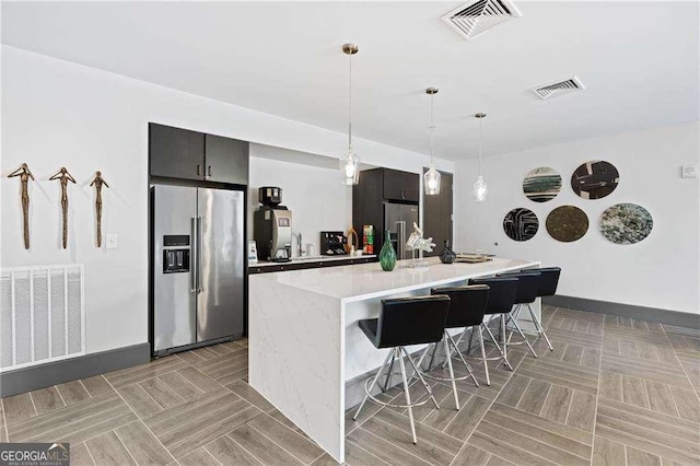 775 Juniper St NE Unit 111, Atlanta, GA 30308 - kitchen featuring high end fridge, light countertops, a breakfast bar area, and an island with sink