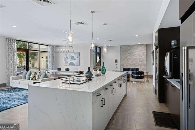 775 Juniper St NE Unit 111, Atlanta, GA 30308 - kitchen featuring open floor plan, light stone counters, white cabinets, recessed lighting, and a large island
