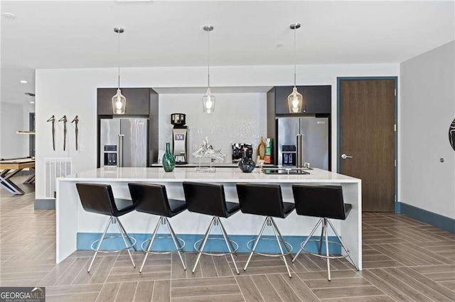 775 Juniper St NE Unit 111, Atlanta, GA 30308 - kitchen featuring high end refrigerator, light countertops, a kitchen bar, and a large island with sink