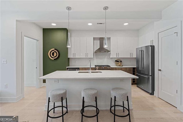 775 Juniper St NE Unit 111, Atlanta, GA 30308 - kitchen featuring appliances with stainless steel finishes, wall chimney exhaust hood, a breakfast bar area, light countertops, and recessed lighting