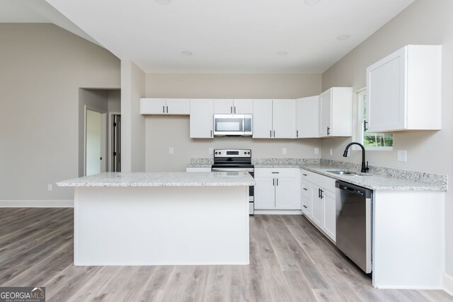 232 Stephens Rd, Cedartown, GA 30125 - kitchen featuring stainless steel appliances, light wood-style flooring, a center island, white cabinets, and light stone counters