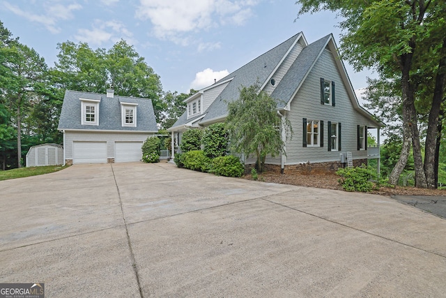 2216 Trammel Rd, Cumming, GA 30041 - view of home's exterior featuring a garage, roof with shingles, concrete driveway, a storage shed, and a chimney