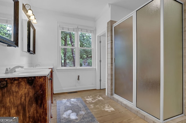 2216 Trammel Rd, Cumming, GA 30041 - bathroom with plenty of natural light, wood finished floors, double vanity, a stall shower, and crown molding