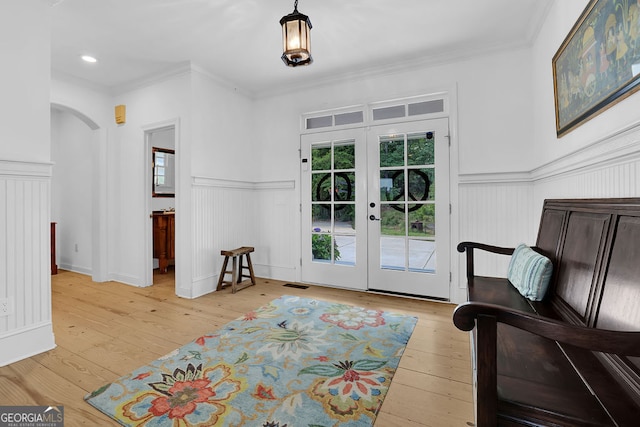 2216 Trammel Rd, Cumming, GA 30041 - entryway featuring french doors, light wood-style floors, arched walkways, wainscoting, and ornamental molding