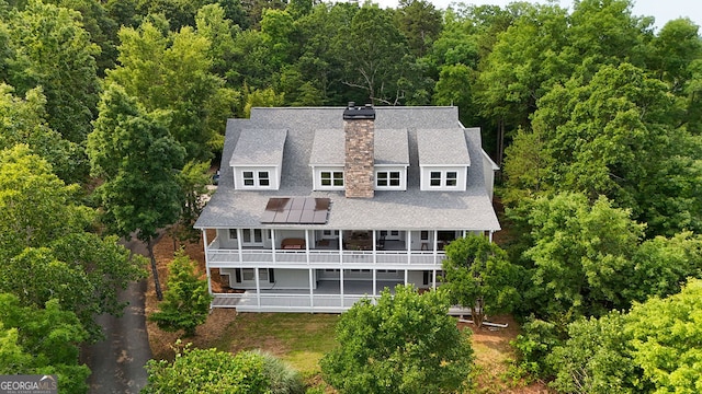 2216 Trammel Rd, Cumming, GA 30041 - rear view of property featuring a balcony, a chimney, a wooded view, and solar panels