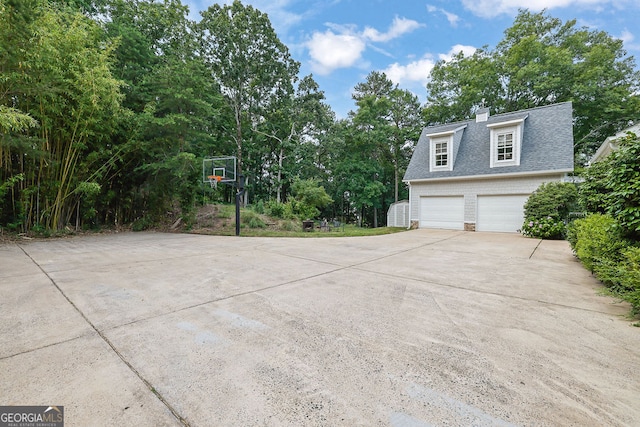 2216 Trammel Rd, Cumming, GA 30041 - view of side of home with driveway, roof with shingles, a chimney, brick siding, and view of scattered trees