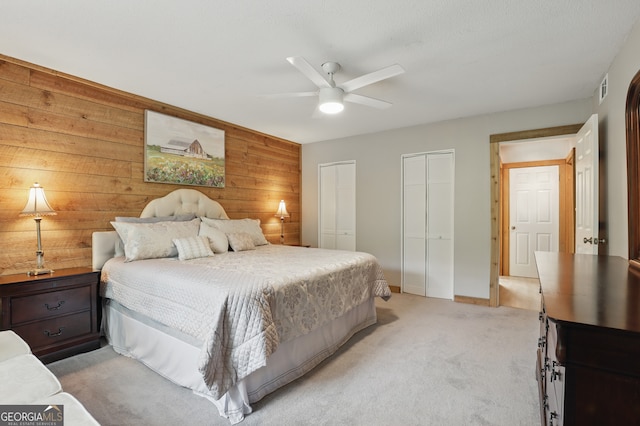 251 Shakespeare Dr Unit 332, Clayton, GA 30525 - bedroom featuring two closets, light colored carpet, wooden walls, and ceiling fan