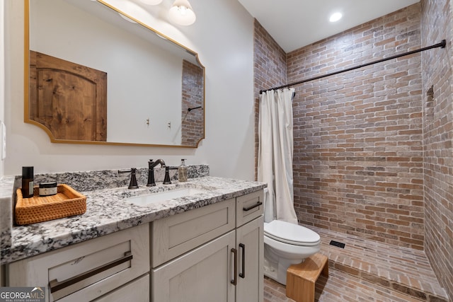 5700 Goolsby Rd, Monticello, GA 31064 - full bath with toilet, vanity, tiled shower, brick wall, and recessed lighting