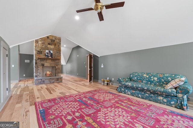 5700 Goolsby Rd, Monticello, GA 31064 - living area featuring wood finished floors, vaulted ceiling, ceiling fan, baseboards, and a stone fireplace