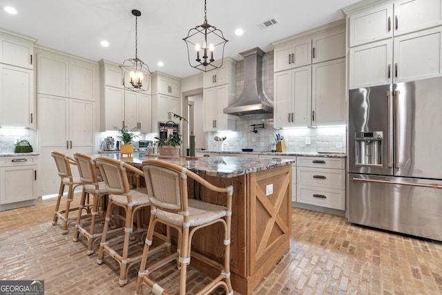 5700 Goolsby Rd, Monticello, GA 31064 - kitchen featuring high end fridge, wall chimney exhaust hood, brick floors, a chandelier, and recessed lighting