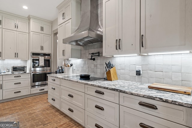 5700 Goolsby Rd, Monticello, GA 31064 - kitchen featuring exhaust hood, black electric cooktop, double oven, decorative backsplash, and light stone counters