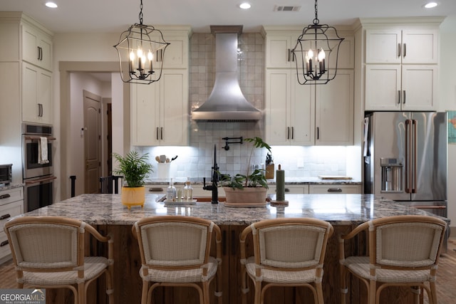 5700 Goolsby Rd, Monticello, GA 31064 - kitchen featuring a chandelier, stainless steel appliances, wall chimney range hood, backsplash, and recessed lighting