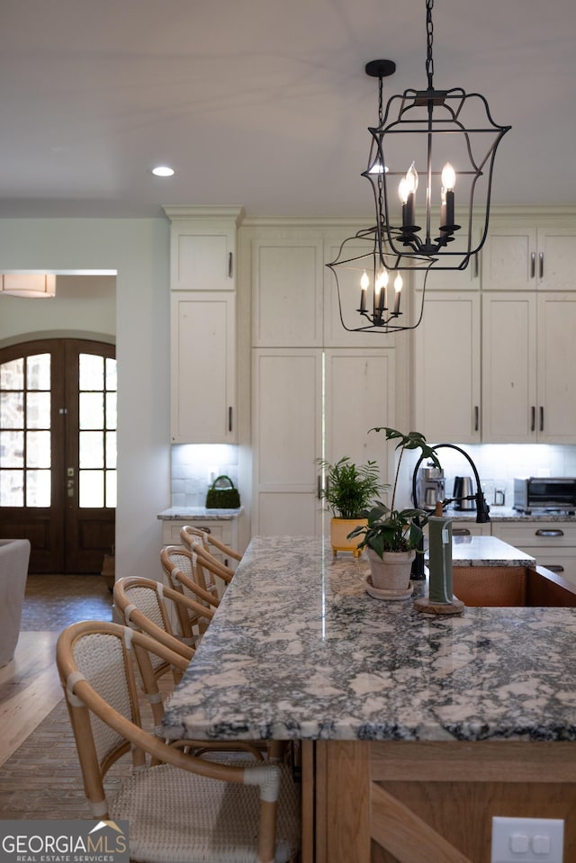 5700 Goolsby Rd, Monticello, GA 31064 - kitchen with a chandelier, french doors, stone countertops, pendant lighting, and light wood-type flooring
