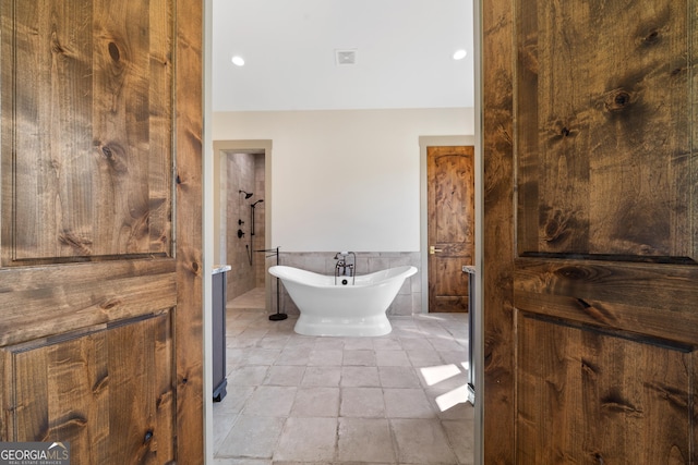 5700 Goolsby Rd, Monticello, GA 31064 - bathroom with a soaking tub, tile walls, a wainscoted wall, and tile patterned flooring