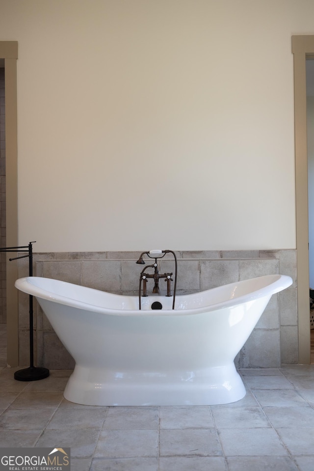 5700 Goolsby Rd, Monticello, GA 31064 - bathroom featuring tile walls, a wainscoted wall, and a soaking tub