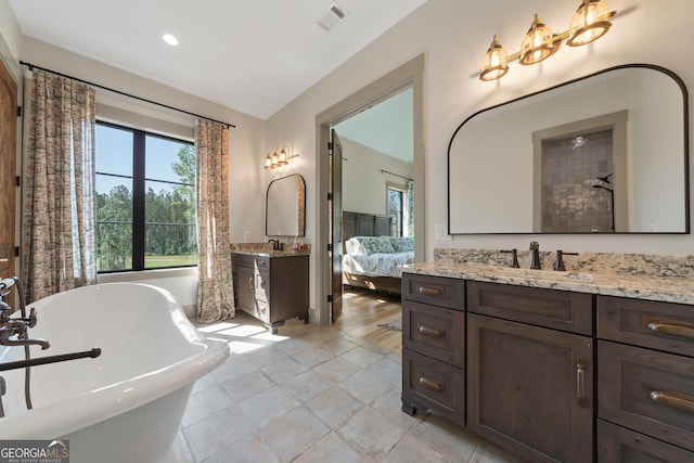 5700 Goolsby Rd, Monticello, GA 31064 - ensuite bathroom with two vanities, a freestanding tub, recessed lighting, and tile patterned flooring