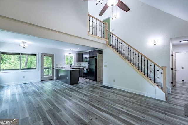 235 Red Bud Ln Unit 5, Hiawassee, GA 30546 - unfurnished living room with wood finished floors, a sink, stairs, ceiling fan, and a high ceiling