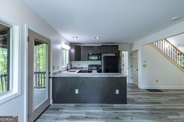 235 Red Bud Ln Unit 5, Hiawassee, GA 30546 - kitchen with black appliances, a sink, dark brown cabinetry, a peninsula, and light wood-style flooring
